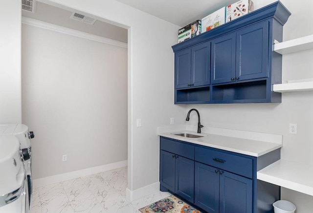 clothes washing area with cabinets, washing machine and dryer, ornamental molding, and sink