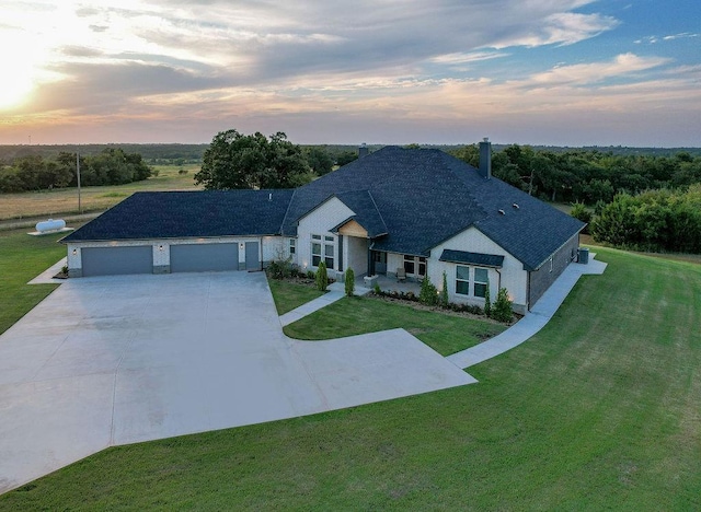 ranch-style house featuring a garage and a yard