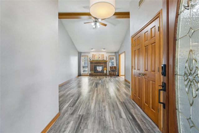 unfurnished living room with ceiling fan, a fireplace, wood-type flooring, and lofted ceiling