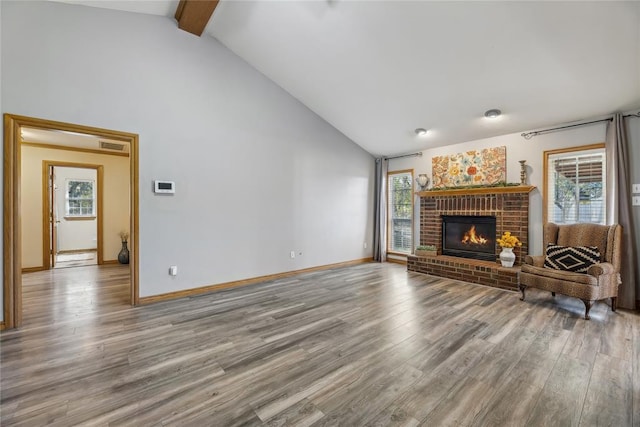 unfurnished living room with beam ceiling, a fireplace, hardwood / wood-style floors, and high vaulted ceiling