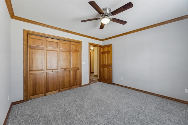 unfurnished bedroom featuring ceiling fan, a closet, carpet floors, and crown molding