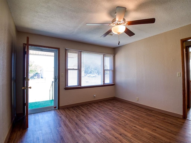 spare room with a textured ceiling, ceiling fan, and dark wood-type flooring