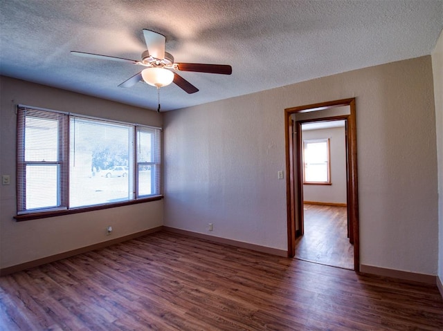 unfurnished room featuring dark hardwood / wood-style floors, ceiling fan, and a textured ceiling