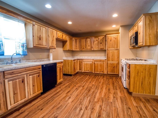 kitchen featuring wood-type flooring, black dishwasher, white stove, and sink