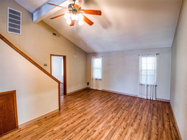 unfurnished living room with light wood-type flooring, vaulted ceiling with beams, and a healthy amount of sunlight