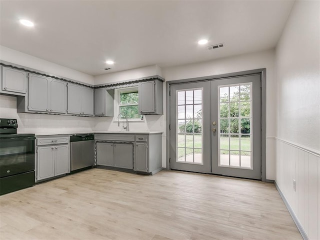 kitchen featuring stainless steel dishwasher, a healthy amount of sunlight, gray cabinetry, and black electric range