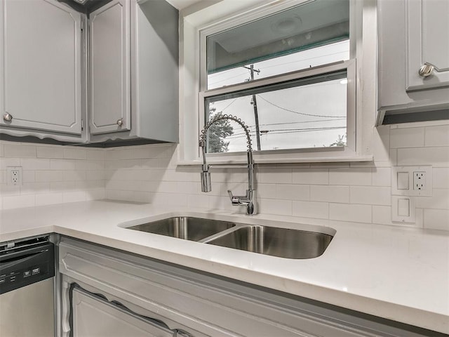 kitchen featuring dishwasher, tasteful backsplash, plenty of natural light, and sink