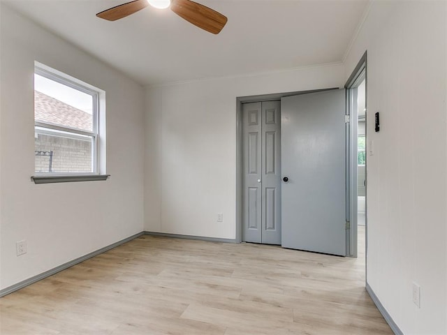 unfurnished bedroom featuring light wood-type flooring, a closet, ceiling fan, and crown molding