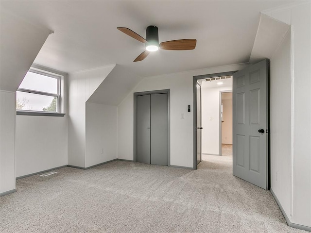 additional living space featuring light colored carpet, ceiling fan, and lofted ceiling