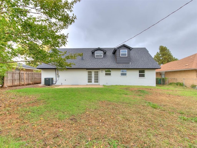 rear view of property featuring french doors, a yard, central AC, and a patio