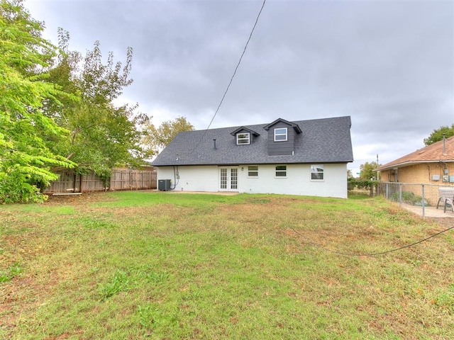 rear view of property with central AC, a yard, and french doors