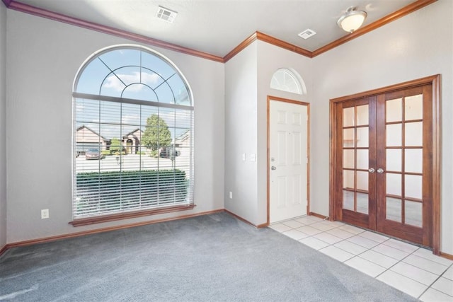 carpeted entryway with crown molding and french doors