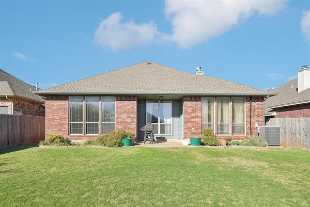 rear view of property featuring a patio, a yard, and central AC