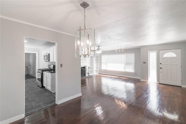 interior space with dark hardwood / wood-style flooring, ceiling fan with notable chandelier, a textured ceiling, and ornamental molding