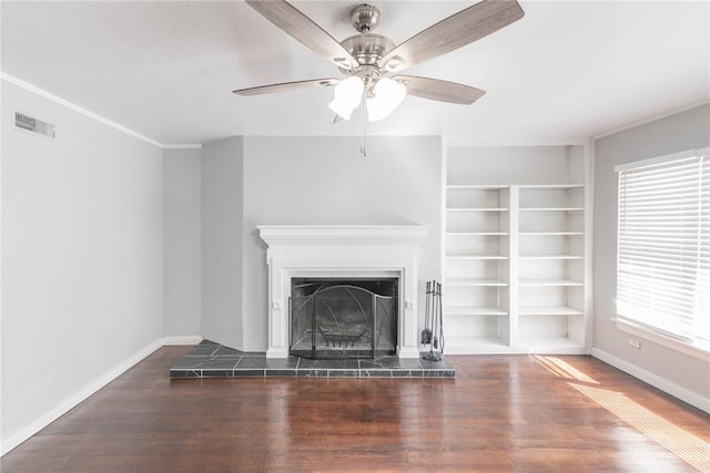 unfurnished living room with a tile fireplace, dark hardwood / wood-style floors, ceiling fan, and crown molding