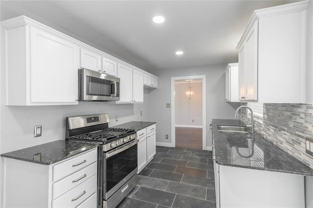 kitchen with white cabinetry, sink, dark stone counters, and appliances with stainless steel finishes