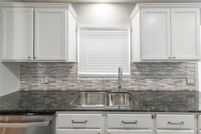 kitchen with dark stone counters, white cabinetry, sink, and stainless steel dishwasher