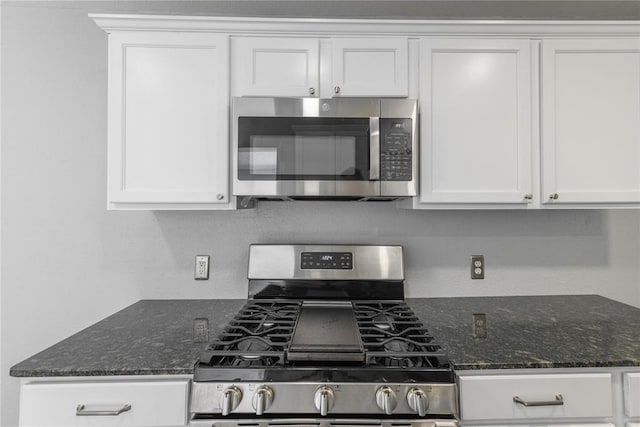 kitchen with white cabinets, dark stone countertops, and stainless steel appliances