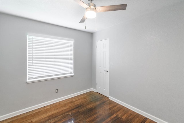 spare room featuring ceiling fan and dark wood-type flooring