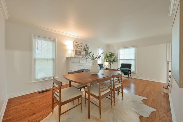 dining space with light hardwood / wood-style floors and crown molding