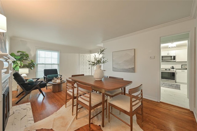 dining space featuring ornamental molding and light hardwood / wood-style flooring