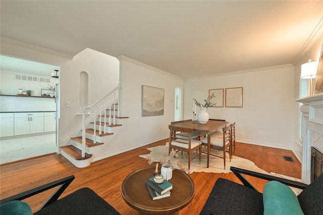 dining area featuring hardwood / wood-style flooring and ornamental molding