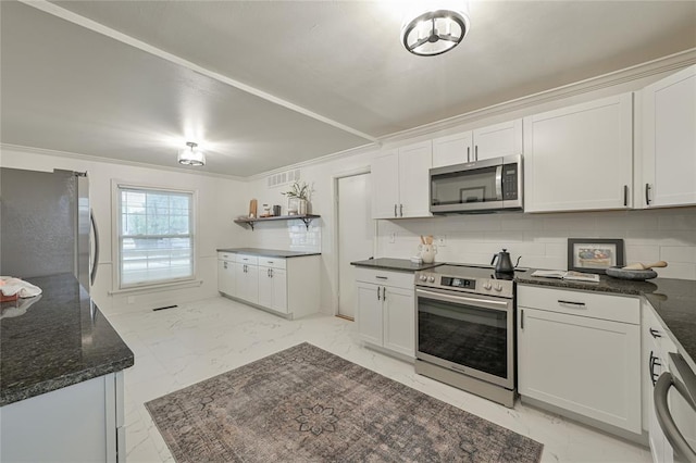 kitchen featuring decorative backsplash, white cabinets, and appliances with stainless steel finishes