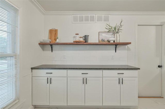 interior details with decorative backsplash and ornamental molding