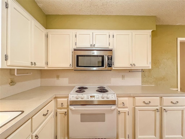 kitchen featuring a textured ceiling, sink, white cabinetry, and electric stove