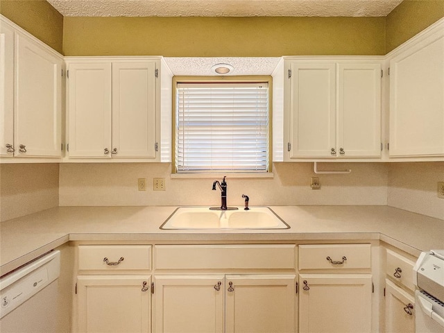 kitchen featuring white cabinets, white appliances, sink, and a textured ceiling