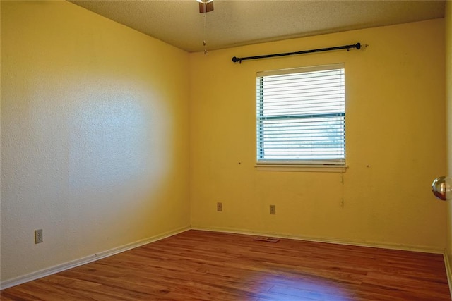 spare room featuring a textured ceiling and hardwood / wood-style flooring