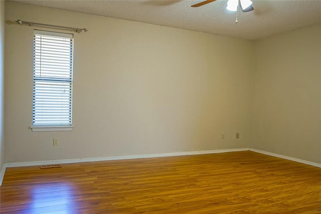 spare room with hardwood / wood-style flooring, ceiling fan, and a textured ceiling