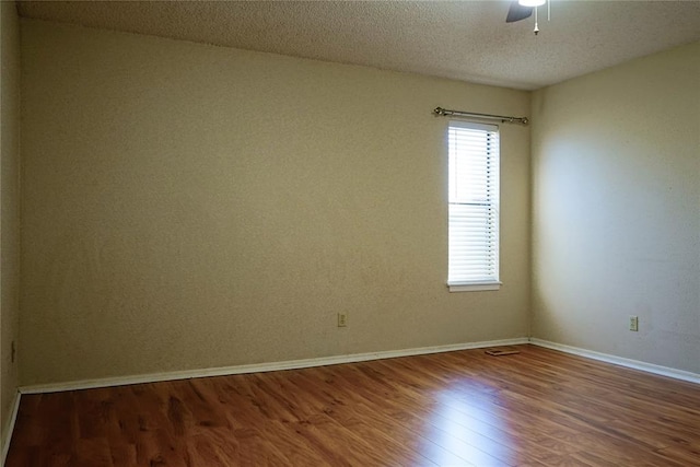 spare room featuring wood-type flooring, a textured ceiling, and ceiling fan