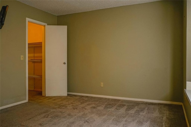 carpeted empty room with a textured ceiling