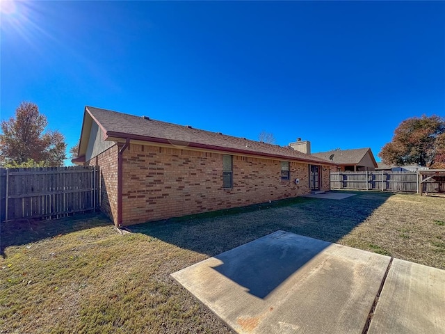 rear view of property with a lawn and a patio