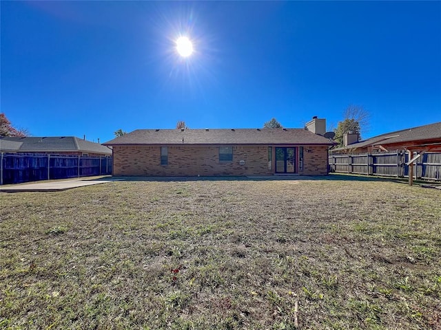 back of property featuring a lawn