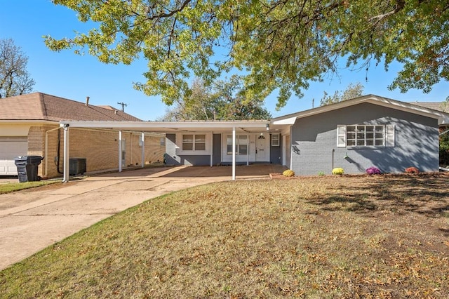 ranch-style house featuring a carport, central AC unit, and a front lawn