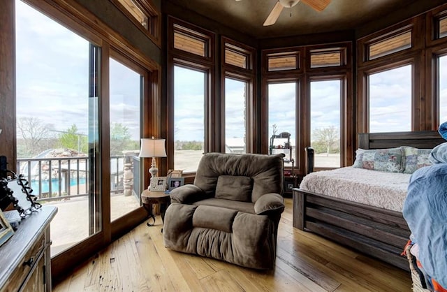 bedroom featuring light wood-type flooring, access to outside, multiple windows, and ceiling fan