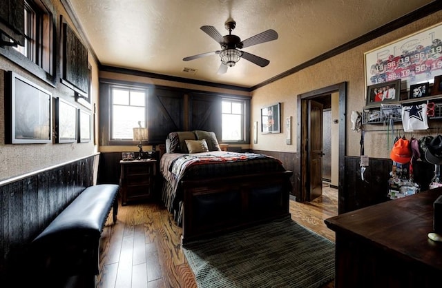 bedroom with ceiling fan, light hardwood / wood-style floors, crown molding, and multiple windows