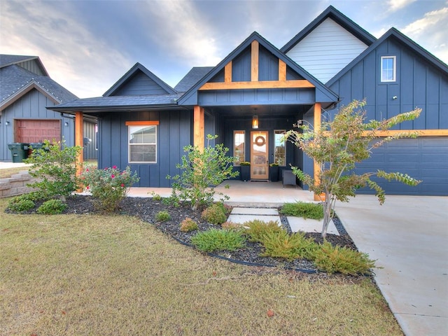 view of front of house featuring a porch, a garage, and a front lawn