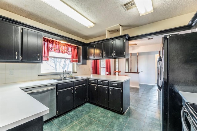 kitchen with tasteful backsplash, appliances with stainless steel finishes, kitchen peninsula, and sink