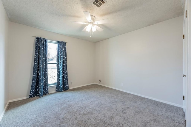 carpeted spare room with ceiling fan and a textured ceiling