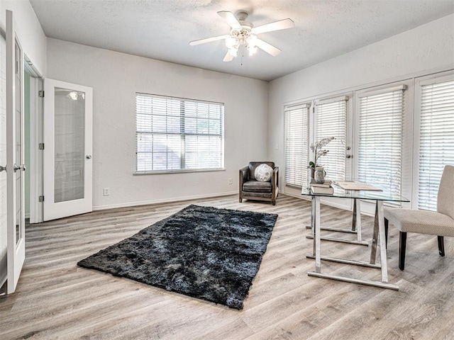 home office featuring hardwood / wood-style floors, ceiling fan, a healthy amount of sunlight, and french doors