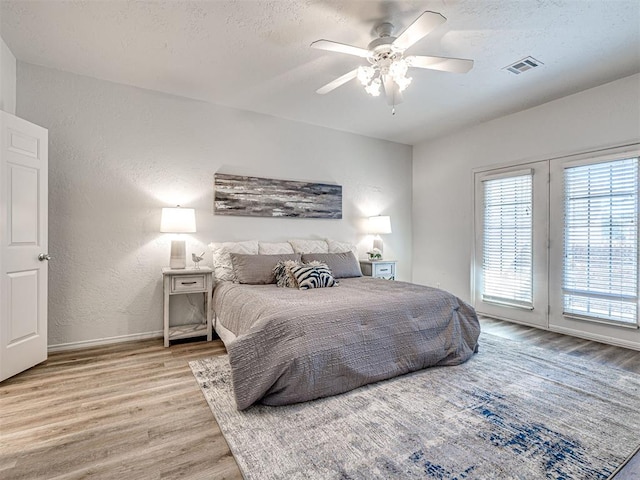 bedroom featuring access to exterior, ceiling fan, and light wood-type flooring