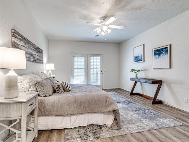 bedroom featuring hardwood / wood-style flooring, ceiling fan, a textured ceiling, and access to outside