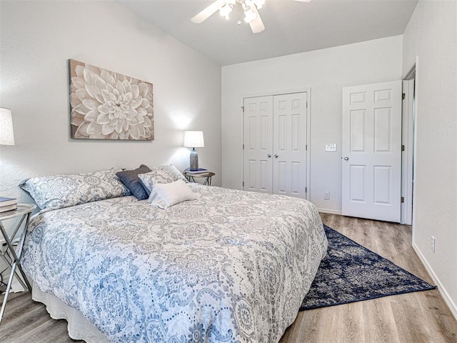 bedroom with hardwood / wood-style floors, a closet, and ceiling fan