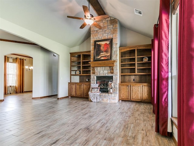 unfurnished living room with a stone fireplace, beamed ceiling, high vaulted ceiling, hardwood / wood-style flooring, and ceiling fan