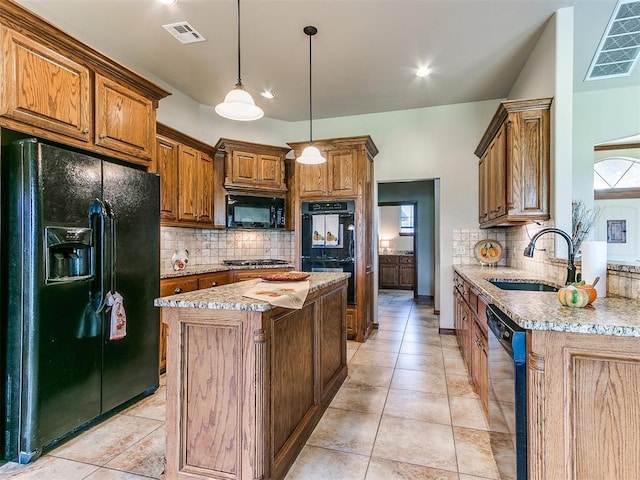 kitchen with pendant lighting, sink, light stone counters, black appliances, and a kitchen island