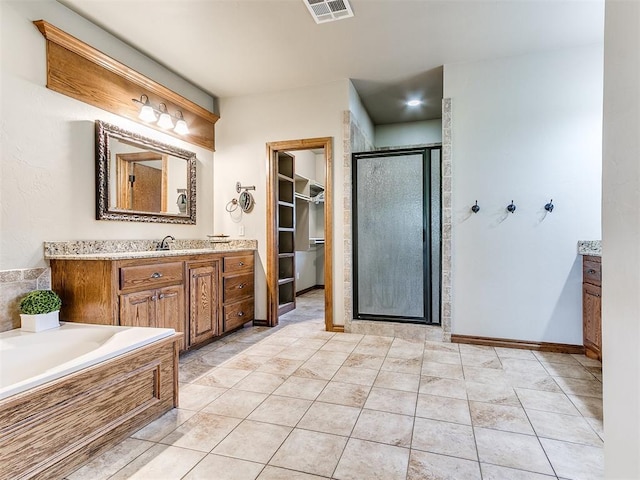 bathroom featuring tile patterned flooring, shower with separate bathtub, and vanity