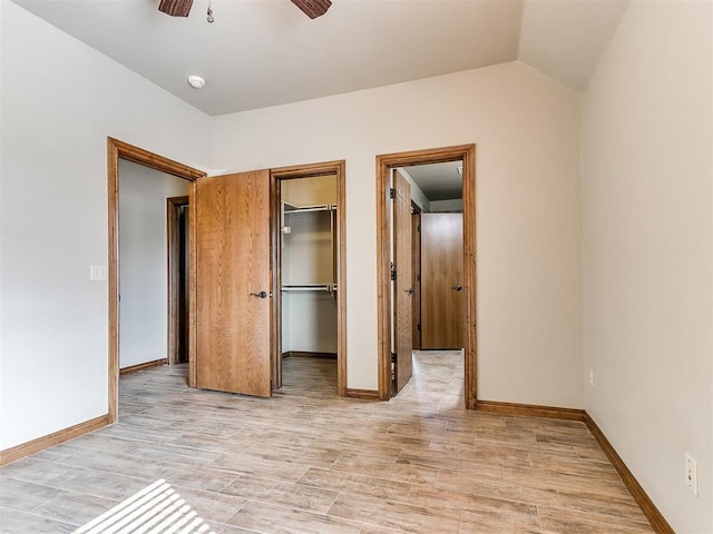 unfurnished bedroom featuring vaulted ceiling, a closet, ceiling fan, and light wood-type flooring